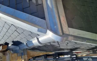 Bague décorative d'un raccordement entre l'arêtier du brisis et du versant en épousant le membron en