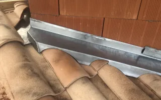 Détail des bavettes crantées, pose des bandes porte-solin en cours