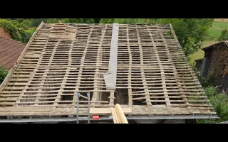 Bâche déroulée sur un versant de la toiture