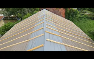 Vue d'ensemble du bâchage de la toiture, les tasseaux respectent l'asymétrie des chevrons de la charpente