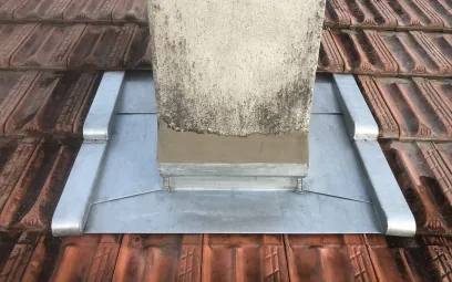 Abergement de cheminée en zinc avec noquets et bande porte solin sur tuile Marseille